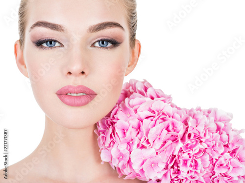 Young beautiful woman with flowers near face.
