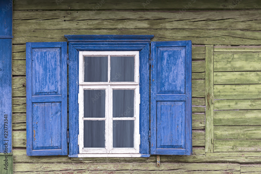 old weathered white window with blue shutters on green wooden wall old weathered white window with blue shutters on green wooden wall
