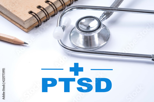 Stethoscope, notebook and pencil with PTSD - post traumatic stress disorder words. Medical concept. War veteran mental health issue. photo