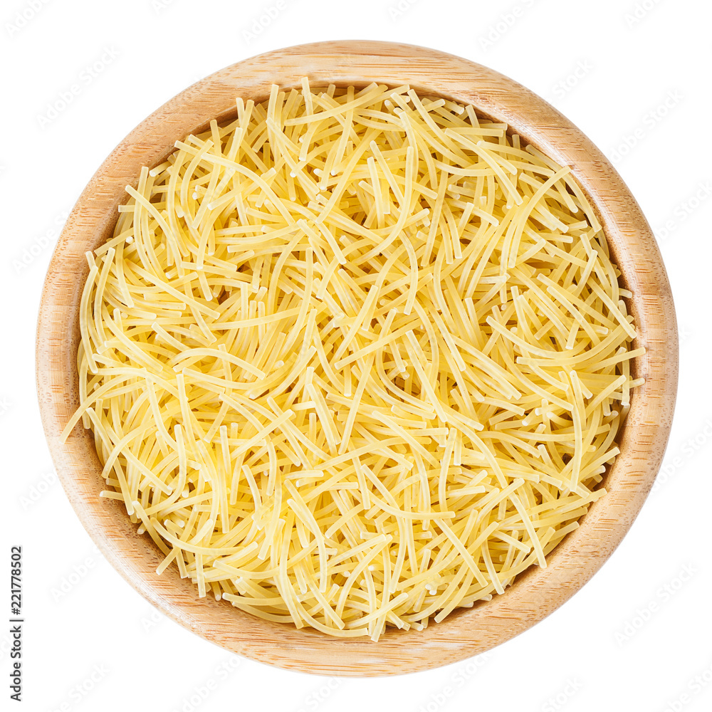 Uncooked vermicelli pasta in wooden bowl isolated on white background with clipping path