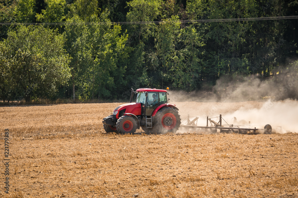 Obraz premium Tractor plows a field - agriculture and agronomy concept