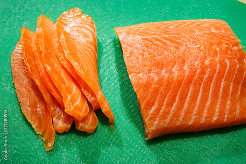 sliced salmon fillet lies on green tablet