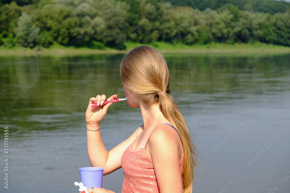 young girl brushes teeth in camping outdoors young girl brushes teeth in camping outdoors