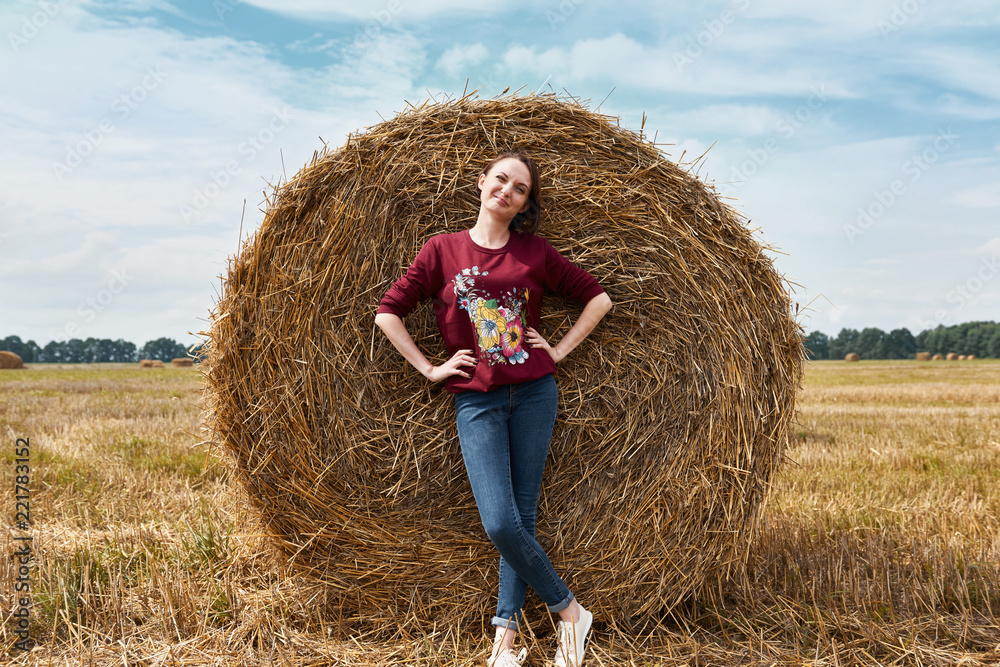 young girl having fun in the field, mowed hay wrapped in a haystack young girl having fun in the field, mowed hay wrapped in a haystack