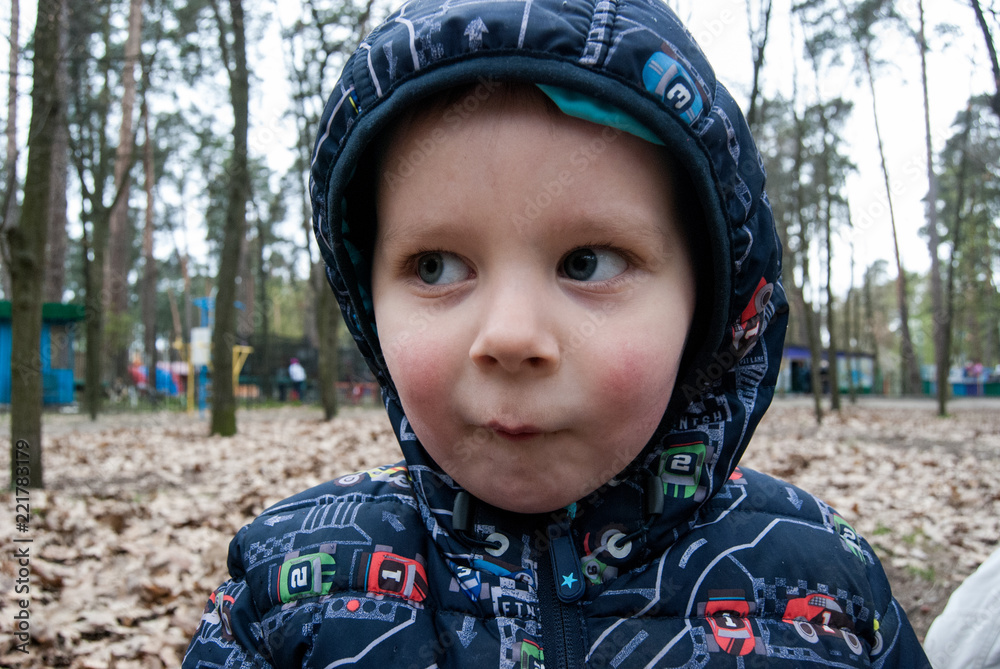 Little boy in a hood in the park. Little boy in a hood in the park.
