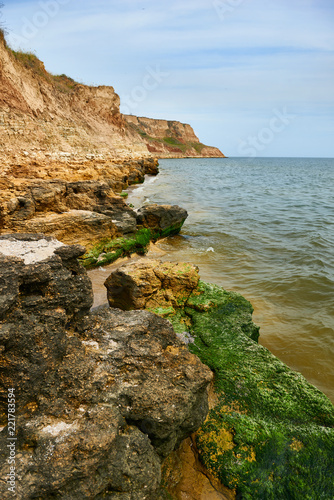 beautiful sea landscape, closeup of stone on the beach, sea coast with high hills, wild nature