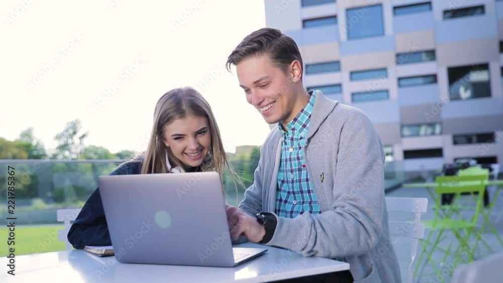 Young Man And Woman Working On Computer Outdoors