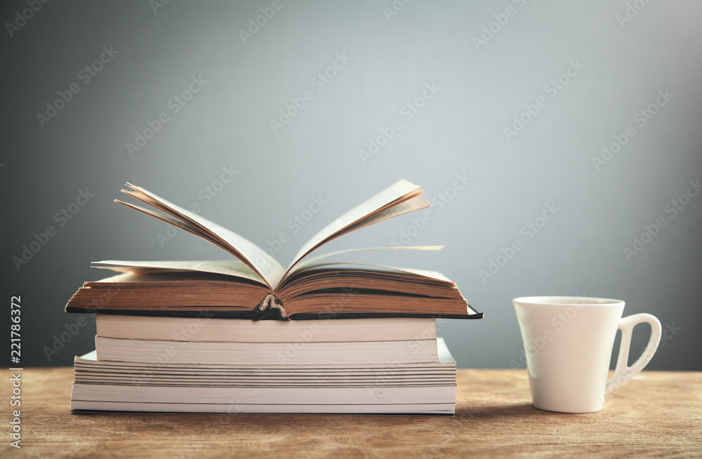 Coffee cup with books on wooden table. Education concept