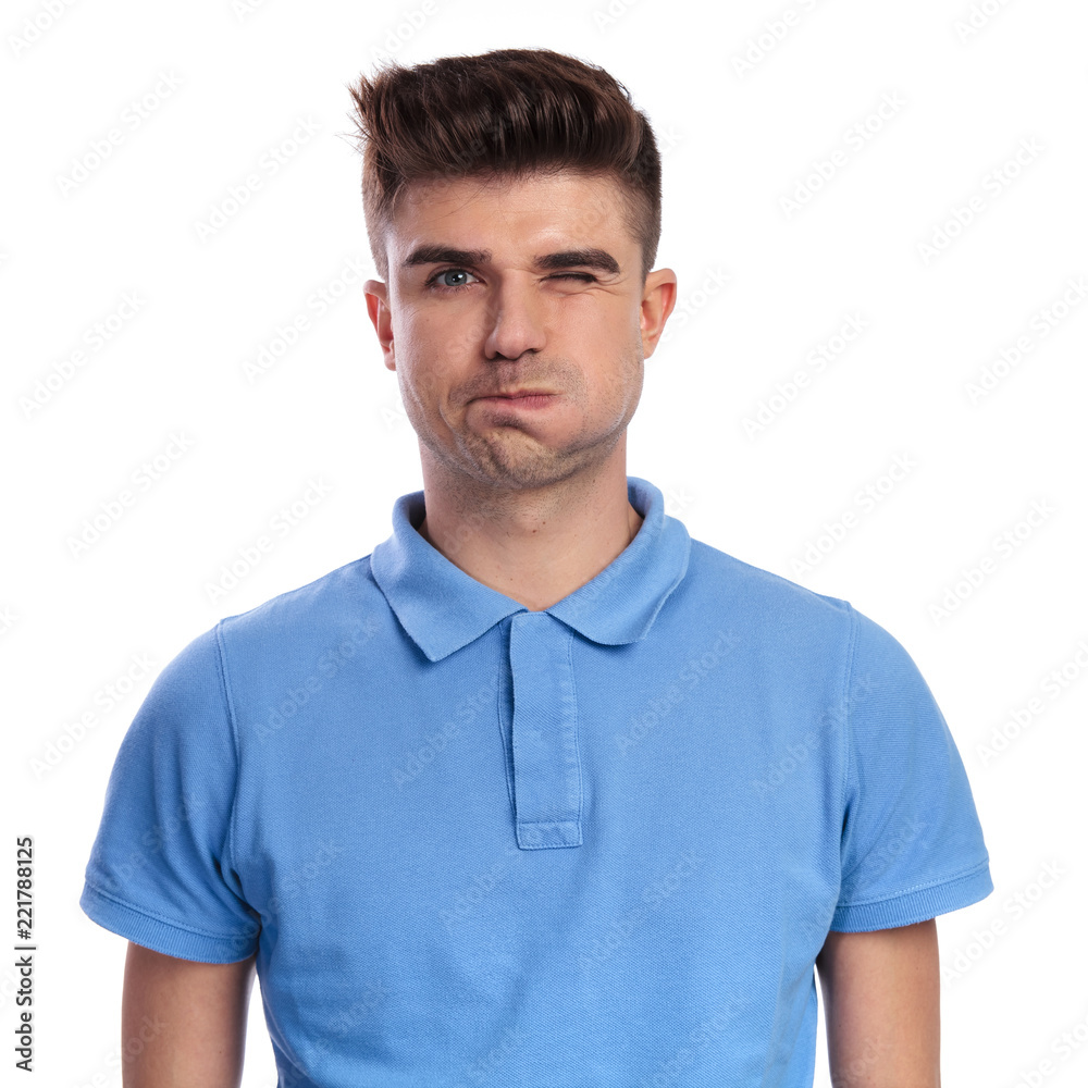 goofy young casual man blows his cheek and winks goofy young casual man blows his cheek and winks