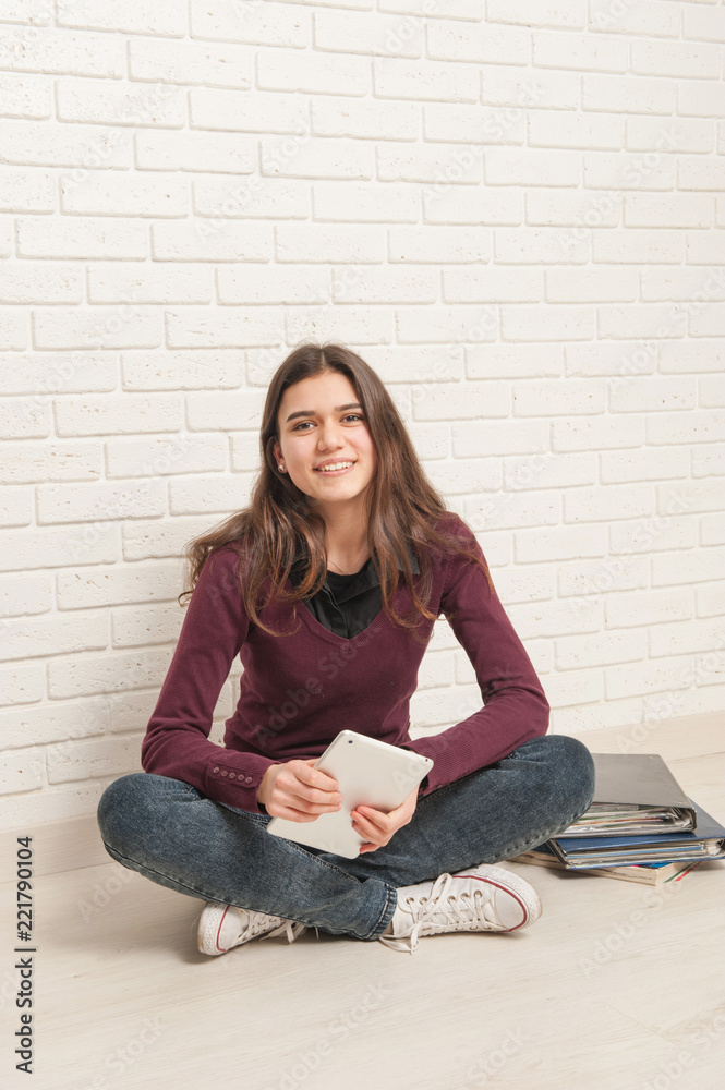 girl sitting on the floor against a brick wall