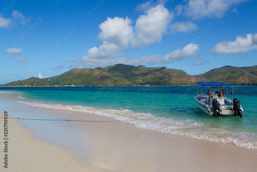 Ausflugsboote am Strand von Curieuse mit Blick auf Praslin, Seychellen.