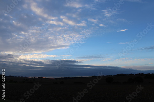 Clouds move away to reveal deep blue evening sky