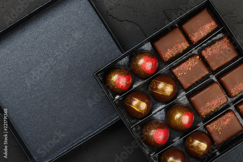 Set of luxury handmade bonbons in box on black background
