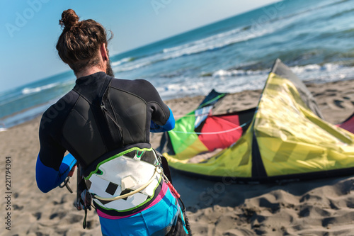 Man sufrers in wetsuits with kite equipment for surfing. © Mediteraneo
