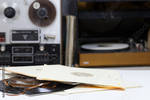 Vinyl record with copy space in front of a collection albums dummy titles. Reel Tape Recorder