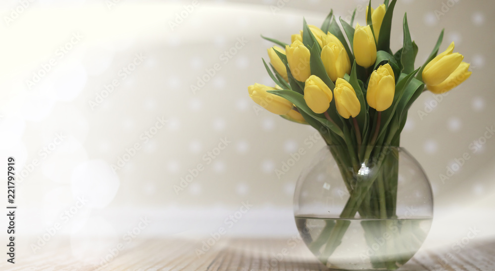  bouquet of yellow tulips in a vase on the floor