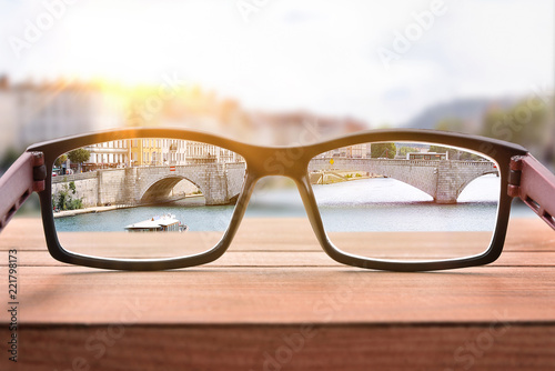 Concept of eyesight correction with glasses on a bridge handrails