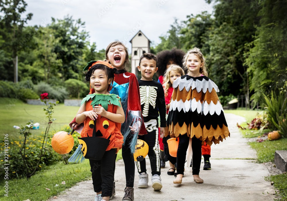 Fototapeta premium Young kids trick or treating during Halloween