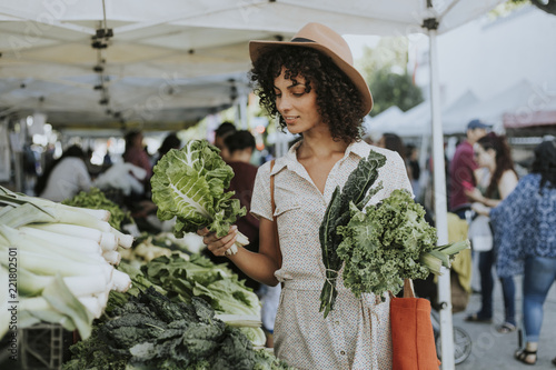 Beautiful woman buying kale at a farmers market photo