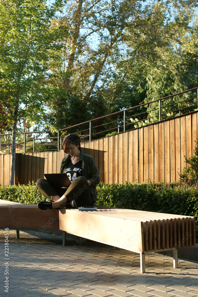 Young woman working in a quiet courtyard of an office building Young woman working in a quiet courtyard of an office building