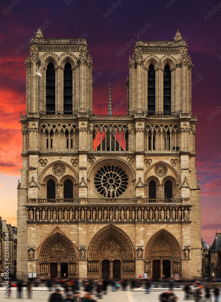 Front view of the Notre-Dame Cathedral in Paris with a dramatic sunset