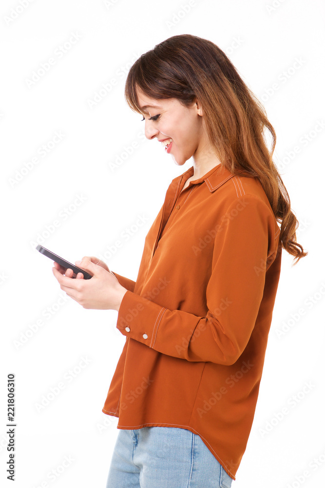 Profile of happy young woman looking at smart phone against isolated white background Profile of happy young woman looking at smart phone against isolated white background