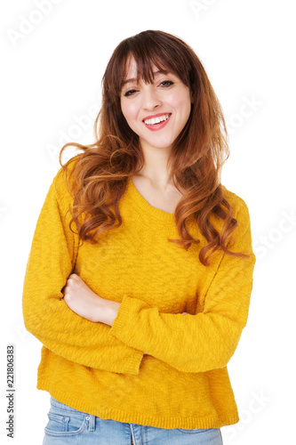 young woman smiling with arms crossed against isolated white background