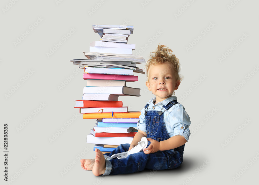 Little boy in denim overalls with books is smiling Little boy in denim overalls with books is smiling