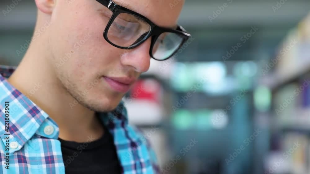 Bookstore. Man Student Reading Books Near Bookshelves Bookstore. Man Student Reading Books Near Bookshelves