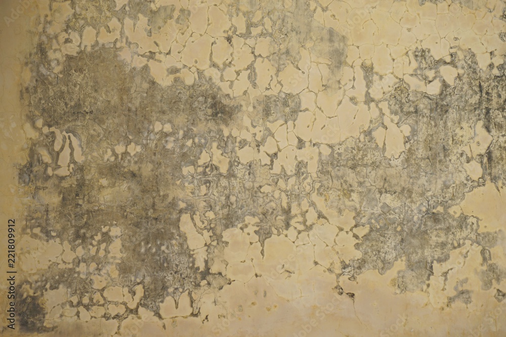 Faded yellow ancient crumbling plaster stucco wall horizontal background