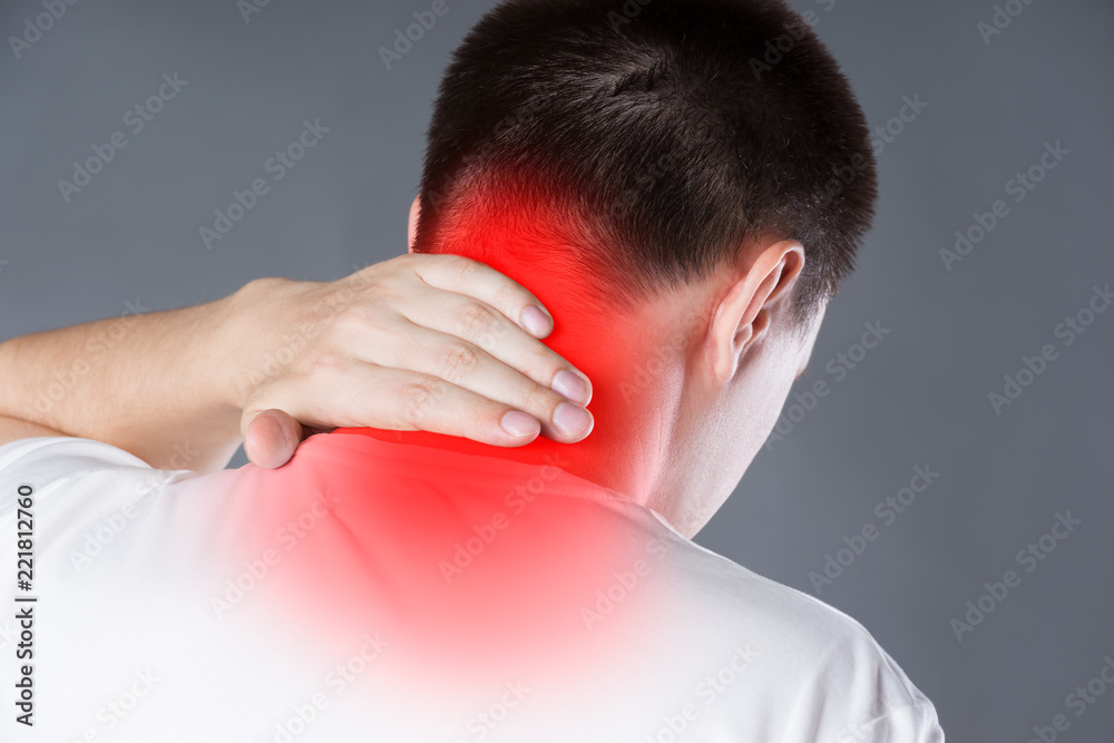 Fototapeta premium Neck pain, man suffering from backache on gray background