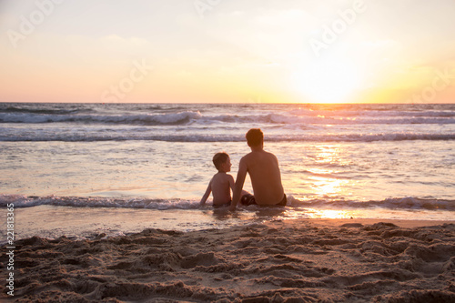 silhouette of father and son at sunset on the beach