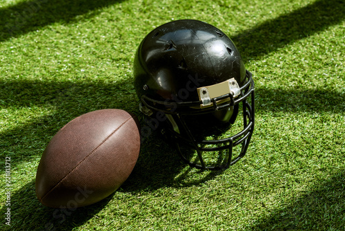 high angle view of american football ball and helmet on green grass