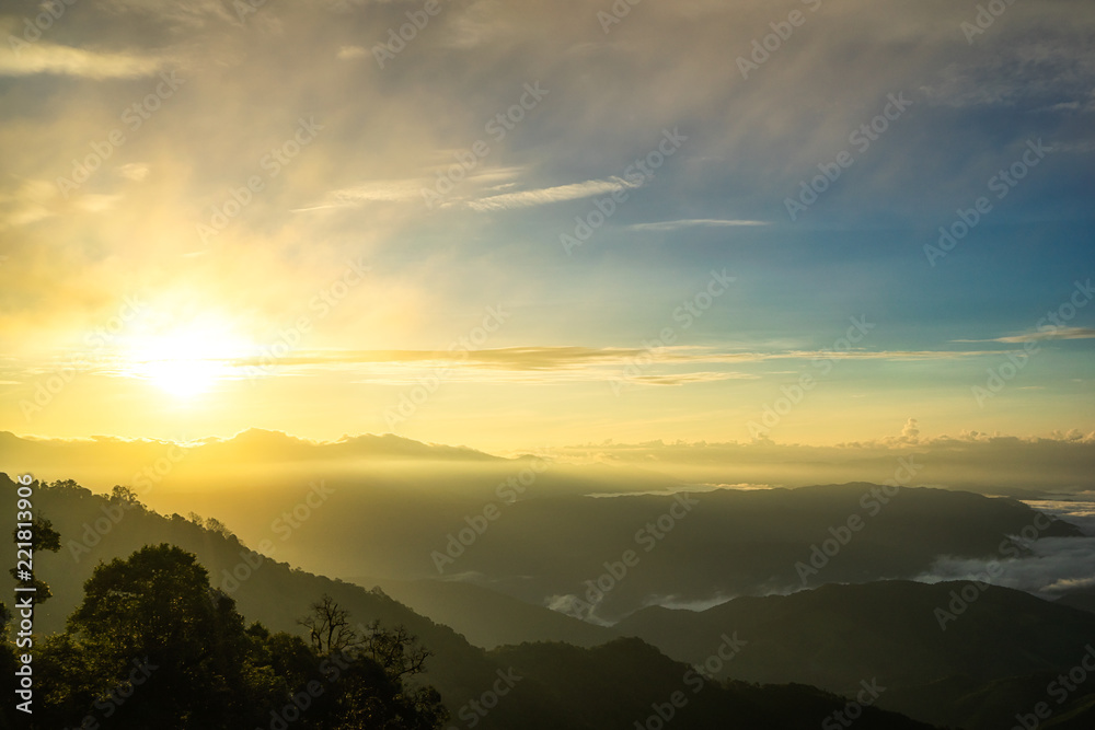 Fog in mountains, fantasy and colorful nature landscape and ray of sunlight through clouds, view from the top view of mountains.  