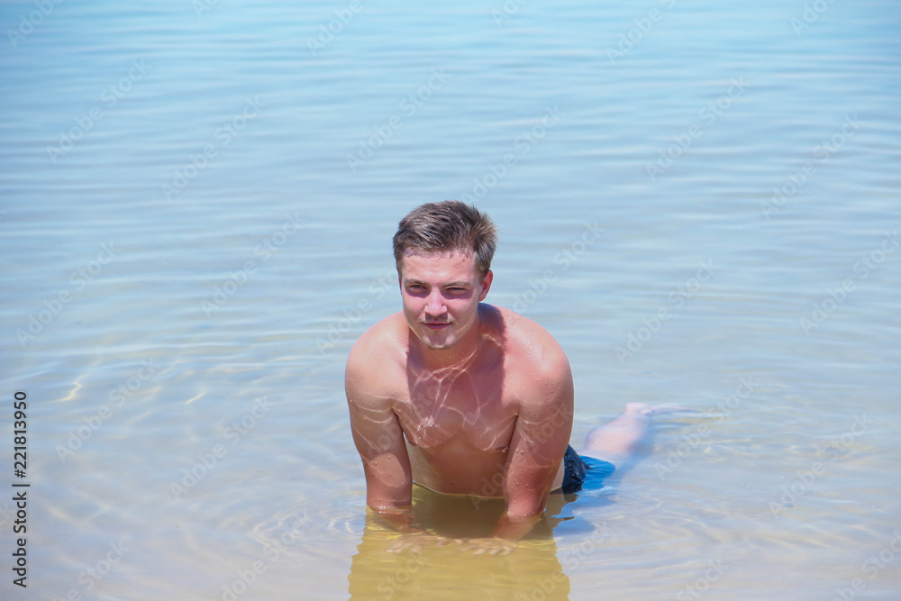 Young attractive sexy man resting in the sea