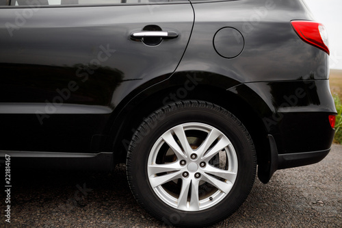Car wheel close-up. Black modern car closeup.  © VAKSMANV