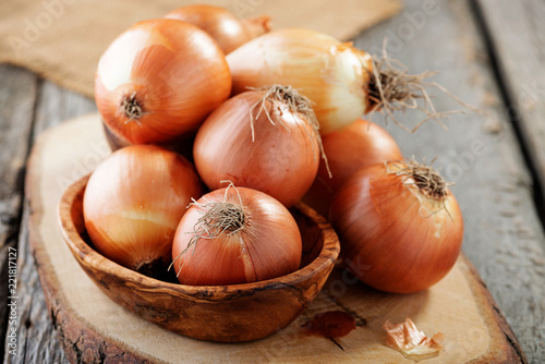 Fresh raw onions on wooden background. 