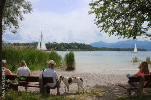 Leute schauen auf den Chiemsee, m Hintergrund die Herreninsel, Bayern  photo