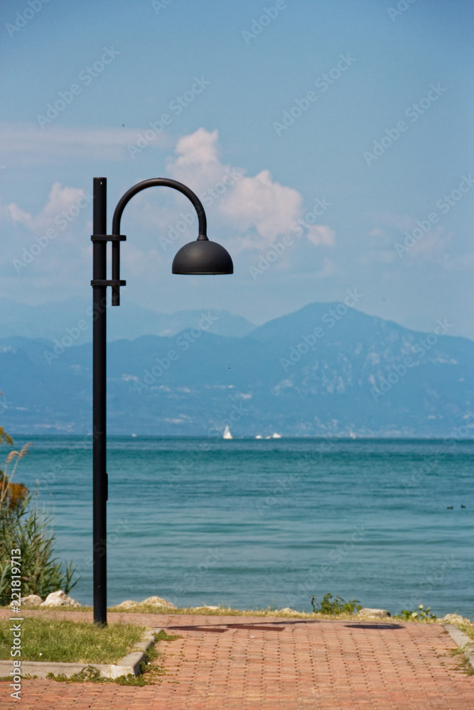 Italy - Lake Garda. Blue waters are lush greenery of Italian nature and the mighty slopes of the Alpine mountains.