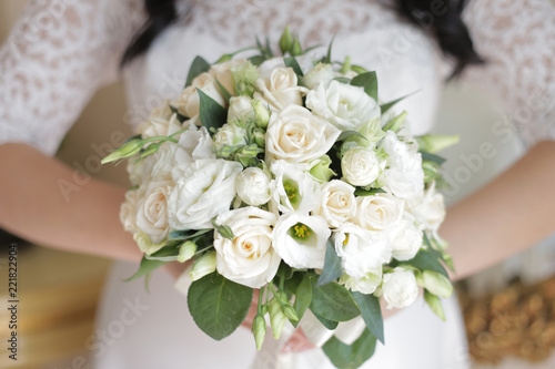 the bride is holding a bouquet of the bride from white roses and eustoma