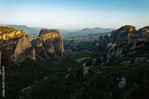 Huge rocks with christian orthodox monasteries at sunrise with Meteora valley in background near Kalambaka, Thessaly, Greece