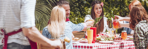 Photography Young students smiling and toasting with drinks during a barbecue party