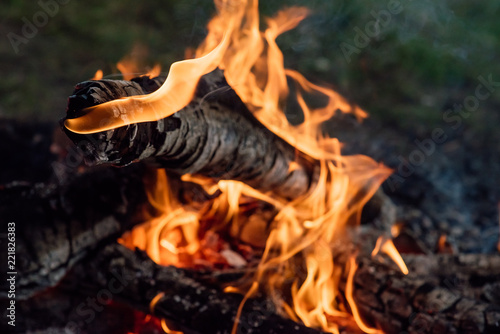 Flame burns in the fire. Fire in the grill with smoke. Arson or natural disaster. The fire is close. Fire in nature. Background bonfire