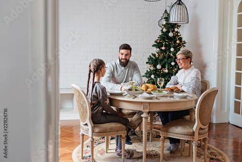 Family of three having lunch for Christmas holidays 