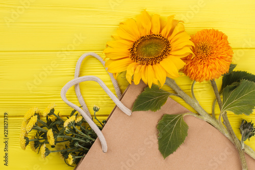 Fototapeta Naklejka Na Ścianę i Meble -  Unripe young sunflowers. Yellow wooden background.
