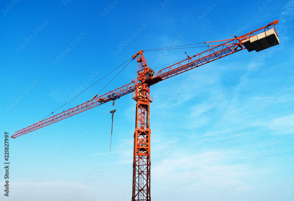 Working red crane in the sky. Construction site. Working red crane in the sky. Construction site.