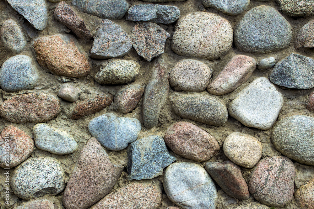 natural stone wall of round stone, front and back background blurred with bokeh effect natural stone wall of round stone, front and back background blurred with bokeh effect