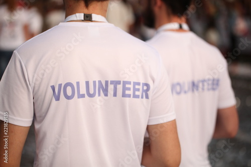 Men in T-shirts with the inscription Volunteers at a sporting public mass event competition photo
