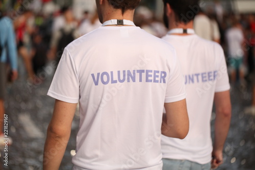 Men in T-shirts with the inscription Volunteers at a sporting public mass event competition