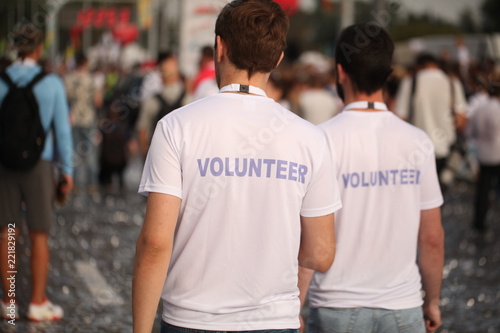 Men in T-shirts with the inscription Volunteers at a sporting public mass event competition